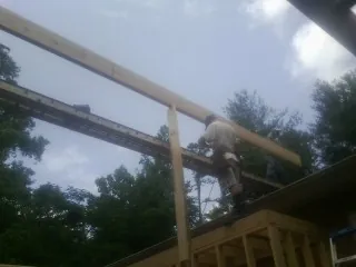 Carpenter setting a ridge beam over a new addition frame — Ice Dam Removal by Roofing Brothers in Crystal Lake