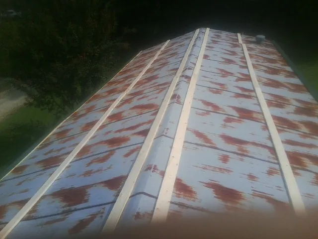 Rusted metal roof panels with new wood purlins before replacement — Storm Damage Roof Repair in Crystal Lake by Roofing Brothers