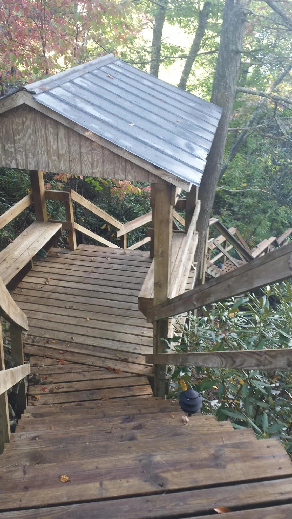 Metal roofed shelter over wooden steps on a wooded walkway — Skylight Repair & Installation work by our crew in Crystal Lake