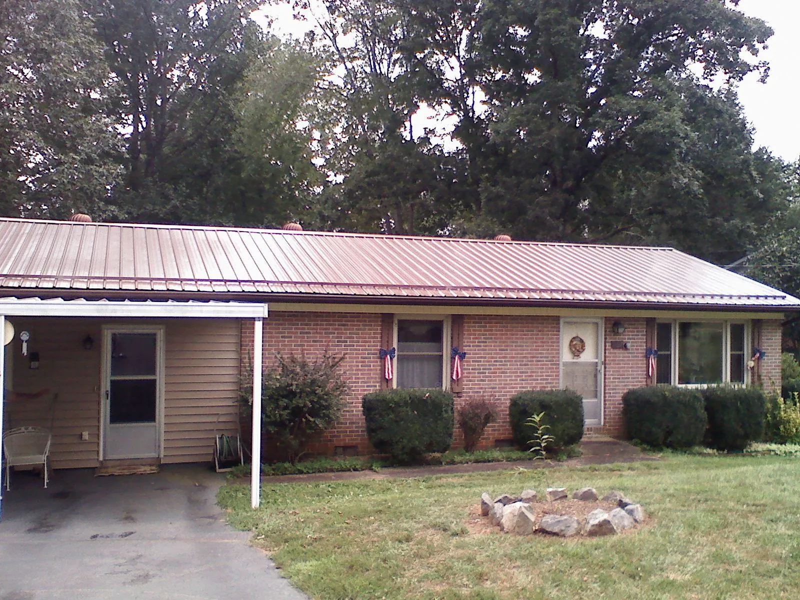Bronze metal roof and carport on a brick ranch home — Roof Repair work by our crew in Crystal Lake